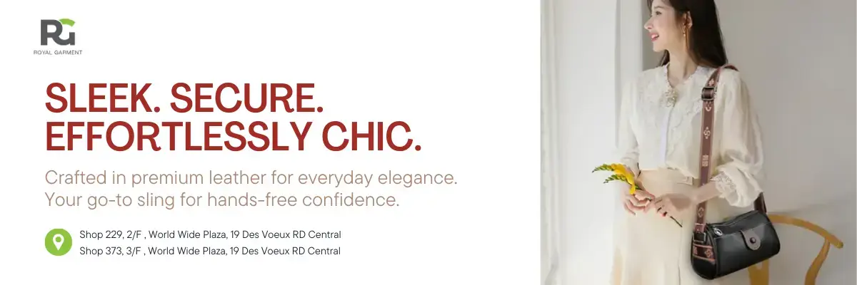 Royal Garment leather sling bag ad featuring a black sling with decorative strap worn over a white blouse and cream skirt. Promotes everyday elegance and hands-free confidence.